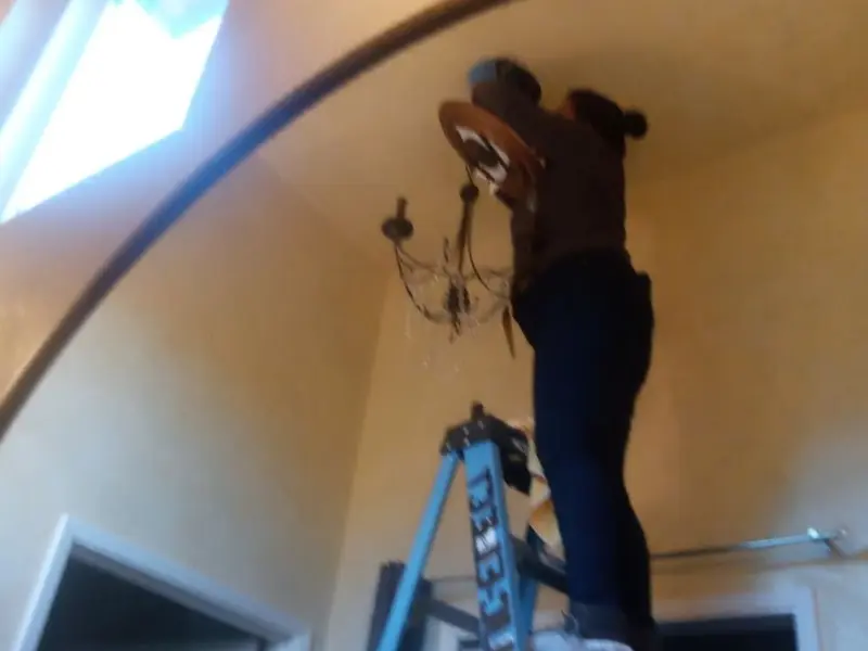 Electrician installing a chandelier in a West Springfield residence